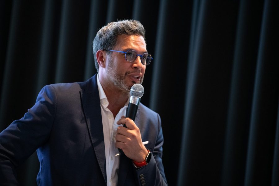 Karim Essemiani prenant la parole lors d'une table ronde pour présenter le groupe GwenneG Financial Solutions